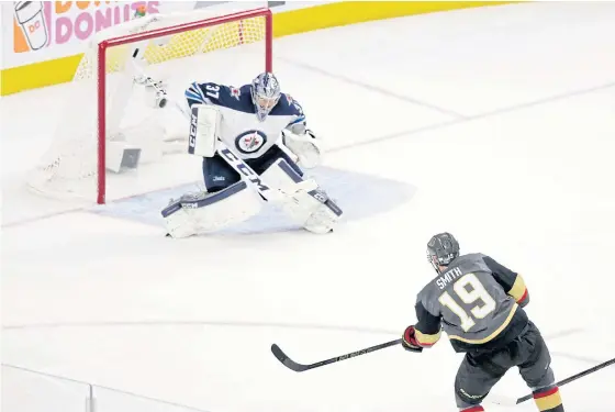  ??  ?? The Golden Knights’ Reilly Smith scores past Jets goaltender Connor Hellebuyck in Las Vegas.