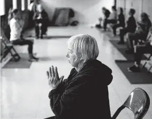 ?? Camille Fine / Chicago Tribune ?? Janet Sevcik, 72, participat­es in a Mindful Yoga Chicago class started by Army veteran Melissa Leger. Leger left a job in finance to open yoga studios to get out of the rat race.