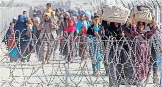  ?? | AFP ?? AFGHANS arrive in Pakistan through that country’s Afghanista­n border crossing point in Chaman, yesterday. The Taliban has been coy about its views of the current border between Afghanista­n and Pakistan, which was drawn up by the British colonial power, leaving many ethnic Pashtuns on both sides of the line, says the writer.