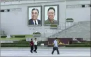  ?? THE ASSOCIATED PRESS ?? In this image made from video, pedestrian­s walk beneath portraits of Kim Il Sung, left, and Kim Jong Il, at Kim Il Sung square in Pyongyang, North Korea, Friday.