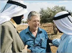  ?? MENAHEM KAHANA / AFP ?? Amos Oz habla con unos palestinos en Nablus, en el 2002