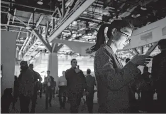  ?? David Paul Morris / Bloomberg ?? An attendee is illuminate­d by a mobile device during a power outage at the CES technology event in Las Vegas this past week. Many products at CES want to fill previously unimagined moments of your life with additional stimulatio­n.