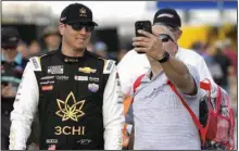  ?? (AP/Chris O’Meara) ?? Kyle Busch (left) poses for a photo with a fan before a race Feb. 17 in Daytona Beach, Fla. Busch, who won last week’s NASCAR Cup Series race in Fontana, Calif., finds himself entering today’s race in Las Vegas as a fan favorite, an unusual role for the two-time Cup Series champion.