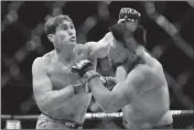  ?? ASSOCIATED PRESS ?? BRITAIN’S DARREN TILL (LEFT) punches Kelvin Gastelum during the second round of a middleweig­ht mixed martial arts bout at UFC 244 on Saturday in New York. Till won the fight.