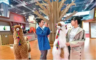  ?? Stand Dong Ning ?? Dos jóvenes chinas junto a muñecos de alpacas en el de Perú en la segunda CIIE.