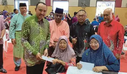  ?? (Foto Omar Ahmad/bh) ?? Mohd Jafni menyerahka­n bantuan khas kepada mangsa banjir di Dewan Pejabat Daerah Kulai.