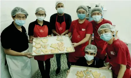  ?? AN photo ?? Employees bake and pack cookies for sale at Silent Teddies Bakery in Kuala Lumpur. It was founded in 2004 by Cindy Leong, a sign language interprete­r.