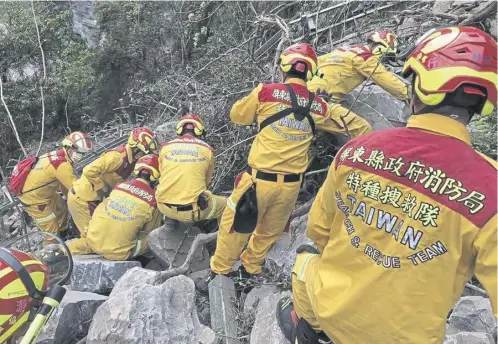  ?? ?? Rescue teams search for the body of a hiker near Hualien while in the city itself, work was going on at a badly tilting building, below
