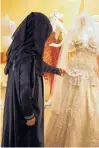  ?? AP FILE PHOTO ?? A Saudi woman checks a wedding dress at a shop in Riyadh, Saudi Arabia. The increase in single women has alarmed the country’s clerics, who have responded by pushing for early marriage and preaching on the evil consequenc­es of spinsterho­od.