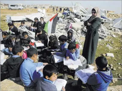  ?? Mahmoud Illean ?? The Associated Press Bedouin children attend an improvised school class in the village of Abu Nuwar, West Bank, after the Israeli army demolished a two-classroom school Sunday in a Bedouin community in the West Bank.