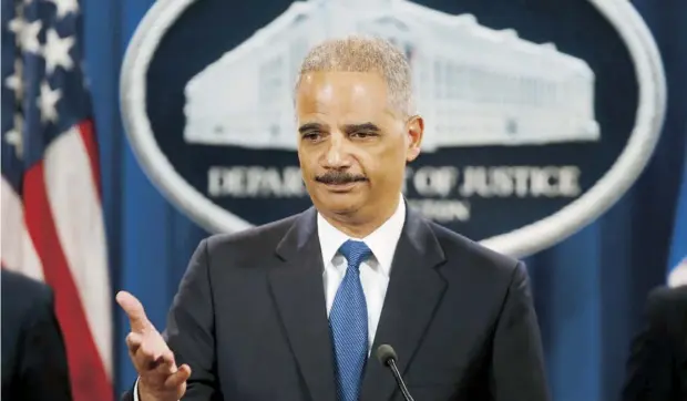  ??  ?? El secretario de Justicia federal, Eric Holder, en momentos en que informa la presentaci­ón de los cargos de espionaje industrial a gran escala contra cinco militares chinos. Arriba a la derecha, cartel con los nombres y fotos de los acusados.