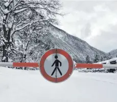  ?? FOTO: DPA ?? Winterchao­s in Bayern und Österreich: Die Straße von Garmisch-Partenkirc­hen nach Österreich ist am Grenzüberg­ang Mittenwald-Scharnitz aufgrund der Lawinengef­ahr gesperrt.