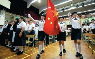  ?? CALVIN NG / CHINA DAILY ?? Left: Students from HKFEW Wong Cho Bau Secondary School in Tung Chung in the New Territorie­s mark the new semester by singing the national anthem and taking part in a flag-raising ceremony.