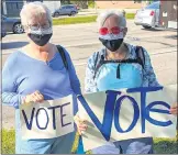  ??  ?? Mary Watkins, left, and Kathi Moore wore their RBG masks during the peaceful demonstrat­ion.