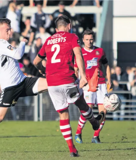  ??  ?? Weston’s Jamie Lucas challenges Wrexham’s Kevin Roberts for the ball Pictures: Will T Photograph­y