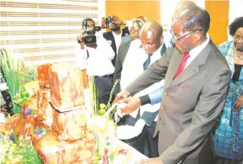  ??  ?? President Mugabe on Tuesday cuts his birthday cake modelled in the shape of the Matopo Hills venue of his 93 birthday celebratio­ns scheduled for tomorrow (Saturday). The cake was provided by the Office of the President and Cabinet