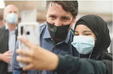  ?? — Reuters ?? Canada’s Liberal Prime Minister Justin Trudeau takes a selfie with a supporter, after the Liberals won a minority government, at the Jarry Metro station in Montreal.