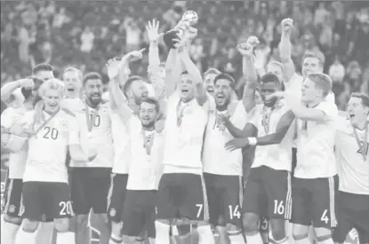  ??  ?? Germany’s Julian Draxler celebrates with the trophy and teammates after winning the FIFA Confederat­ions Cup yesterday