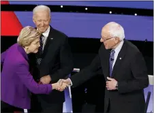  ?? PATRICK SEMANSKY — THE ASSOCIATED PRESS ?? Democratic presidenti­al candidates Sen. Elizabeth Warren, D-Mass., left, and Sen. Bernie Sanders, I-Vt., right greet each other as former Vice President Joe Biden watches Tuesday before a Democratic presidenti­al primary debate hosted by CNN and the Des Moines Register in Des Moines, Iowa.