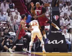  ?? AP photo ?? The Heat’s P.J. Tucker (17) and Gabe Vincent defend against the Hawks’ De’Andre Hunter during the first half of Miami’s series-clinching win over Atlanta on Tuesday.