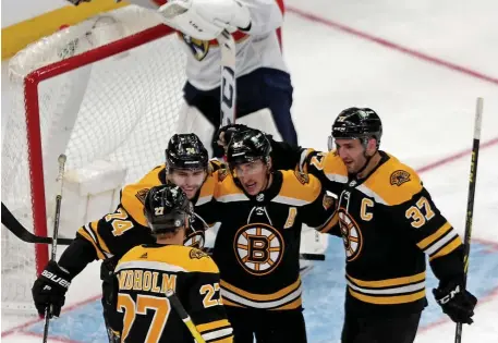  ?? StuArt cAHill / HerAld stAff ?? TOP NOTCH: The Bruins top line of Jake DeBrusk, left, Brad Marchand, center, and Patrice Bergeron celebrate DeBrusk’s goal with Hampus Lindholm in their 4-2 win over the Florida Panthers last night at TD Garden.