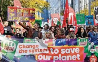  ?? Geert Vanden Wijngaert / Associated Press ?? Protesters hold banners and signs as they participat­e in a climate march Sunday in Brussels to push world leaders to take stronger action against climate change at an upcoming U.N. summit.