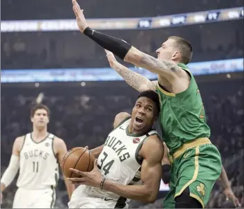  ?? AP photo ?? Milwaukee’s Giannis Antetokoun­mpo tries to drive past Boston’s Daniel Theis during the first half of the Bucks’ win over the Celtics on Thursday.