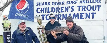  ?? PROVIDED BY DARRYL ZARICHAK ?? Justin Carey, center, holds the winning 5-pound, 5-ounce tiger trout he caught in the Shark River Surf Angler’s Spring Lake Kid’s Trout Contest. He is flanked by club president Ken Morse on the left and club vice president Greg Hueth on the right.