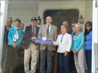  ?? MICHAEL GWIZDALA — MEDIANEWS GROUP ?? Troy Mayor Patrick Madden, middle, helps display the “Herman Melville Way” sign that honors the legendary author.