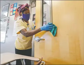  ?? (AP/LM Otero) ?? Amid concerns of the spread of covid-19, Alma Odong wears a mask Tuesday as she cleans a classroom at Wylie High School in Wylie, Texas.