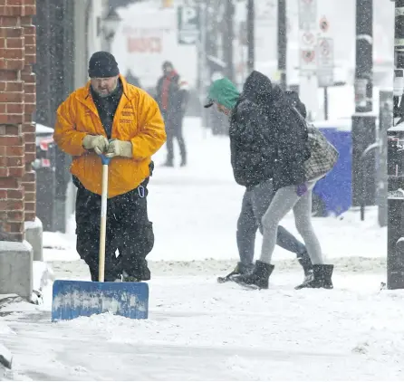  ?? CLIFFORD SKARSTEDT/EXAMINER FILES ?? A worker clears a sidewalk along George St. during snowy weather on Jan. 10, 2017 in Peterborou­gh. The Weather Network says Peterborou­gh will have above average snowfall this winter.