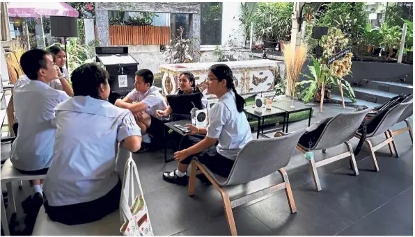  ??  ?? At death’s door: Thai teenagers lounging beside a coffin at the Kid Mai Death Awareness Cafe in Bangkok. — AFP