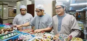  ??  ?? (From left) Triplets Muhamad Zarif Fikri, Muhamad Zazali Fikri and Muhamad Zaini Fikri looking at souvenirs in Makkah yesterday.