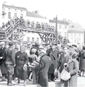  ?? (Photos: Wikimedia Commons) ?? THE LODZ Ghetto’s footbridge over Hohenstein­er Strasse (today known as Zgierska Street).