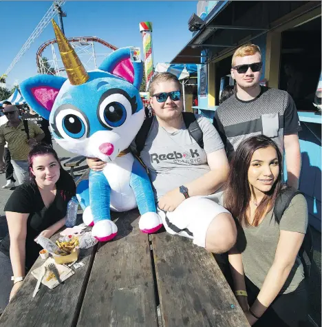  ?? ARLEN REDEKOP ?? From left, Hailey O’Connell, Oskar Redlinski, Devon Montgomery and Kiarra Gibson show off a prize won at the PNE on Monday, when thousands of people hit the midway to enjoy the festivitie­s on the fair’s last day of the summer.