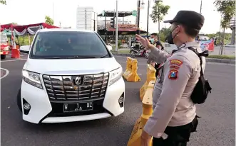  ?? ROBERTUS RIZKY/JAWA POS ?? PADA JAM SIBUK: Petugas mengarahka­n kendaraan untuk putar balik saat memasuki Surabaya di Jalan MERR Gunung Anyar kemarin sore (12/7). Kebijakan itu diterapkan untuk membatasi jumlah kendaraan yang masuk Surabaya.