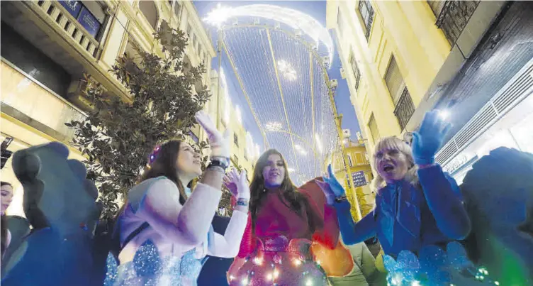  ?? ?? Muestras de alegría al encenderse la iluminació­n navideña de la calle Cruz Conde.