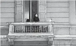  ?? ALESSANDRO GRASSANI/THE NEW YORK TIMES ?? A woman stands on a balcony on March 15 in Milan. Italy is under a national quarantine because of the coronaviru­s, which has killed more than 6,000 people in the country.