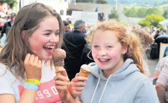  ?? Robert Parry-Jones ?? > Amelia and Erin Evans, from Ruthin, enjoying an ice cream on the showground at the Royal Welsh Show on Thursday. See pages 4&5