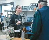  ?? PAUL W. GILLESPIE/STAFF PHOTOS ?? Barista Kassie Young helps a guest. The newest location for the local Rise Up Coffee chain has opened in Severna Park.