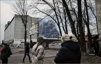  ?? Nariman El-Mofty / Associated Press ?? Smoke rises Saturday behind buildings following explosions in Lviv, western Ukraine. Russia is continuing to strike and encircle urban population­s.