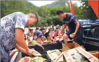  ?? THOMAS PETER / REUTERS ?? Volunteers hand out fruit on Thursday to locals housed in a tent camp after their homes were damaged by the earthquake in Jiuzhaigou, Sichuan province, on Tuesday.