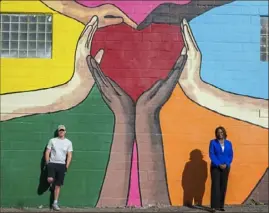  ?? Steve Mellon/Post-Gazette ?? PPG Foundation executive director Malesia Dunn, right, says PPG plans to invest more into supporting diversity. PPG funded a project that includes a mural in the Strip Distict painted by artist Matt Speck, left.