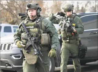  ?? Antonio Perez / Associated Press ?? Police officers armed with rifles gather at the scene where an active shooter was reported in Aurora, Ill., on Friday.