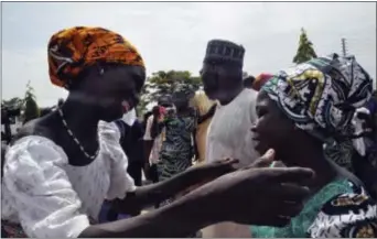  ?? OLAMIKAN GBEMIGA - THE ASSOCIATED PRESS ?? Family members celebrate as they embrace a relative, one of the released kidnapped schoolgirl­s, in Abuja, Nigeria, Saturday. The 82 Nigerian schoolgirl­s recently released after more than three years in Boko Haram captivity reunited with their families...