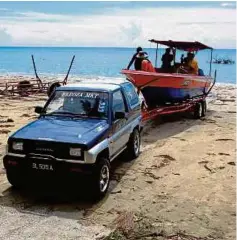  ??  ?? Asiran’s boat is towed by a four-wheel-drive to a fish market at Kampung Lubok Temiang.