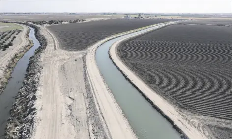  ?? FILE PHOTO BY RANDY HOEFT/YUMA SUN ?? DIRT CANALS ARE BECOMING LESS COMMON IN YUMA COUNTY AGRICULTUR­E as canals are lined with concrete. This 2016 photo shows a drainage canal (left) and an irrigation canal in the Yuma Valley. The irrigation canal brings water to freshly planted crops, while the drainage canal takes used water away.