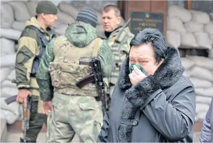  ?? AP ?? A woman waits for news of a loved one stuck inside Zasyadko mine in Donetsk, Ukraine, yesterday. An explosion at the mine is thought to have killed 32 workers.