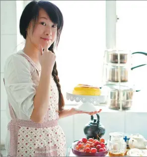  ?? PROVIDED TO CHINA DAILY ?? A woman shows off a newly baked cake at her home in Beijing. More and more Chinese people, especially those from the middle class, are willing to try Western culinary recipes.