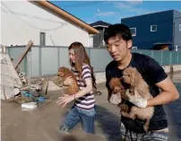  ?? AP, AFP ?? Houses are damaged by mudslide following rains in Kure city, and (right) residents rescue dogs from flooded area in Kurashiki. —